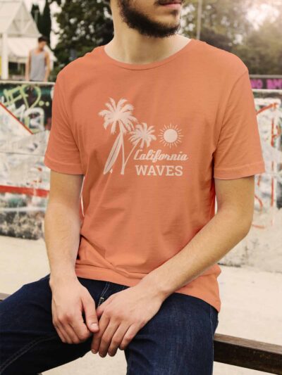 Man wearing a peach T-shirt with white palm trees and a sun graphic saying 'California Waves'.