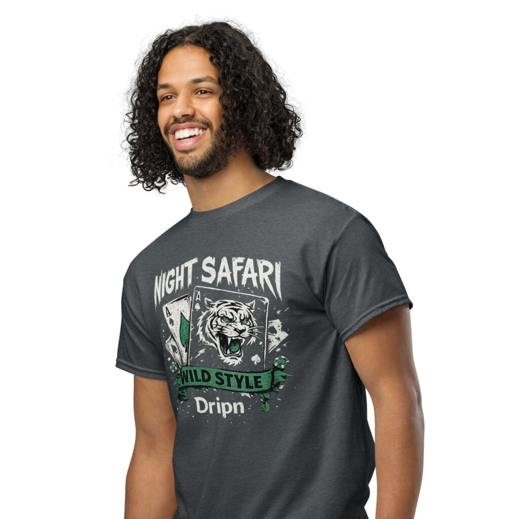Smiling man with long curly hair and beard wearing a dark graphic T-shirt that reads 'Night Safari' with tiger artwork in a white studio background.