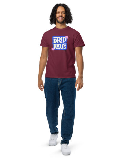 unisex-sports-tee-maroon-front-6a54a1e2140a3jpg Young man with curly hair wearing a maroon T-shirt featuring a blue 'DRIP HAUS' graphic, standing against a white background.