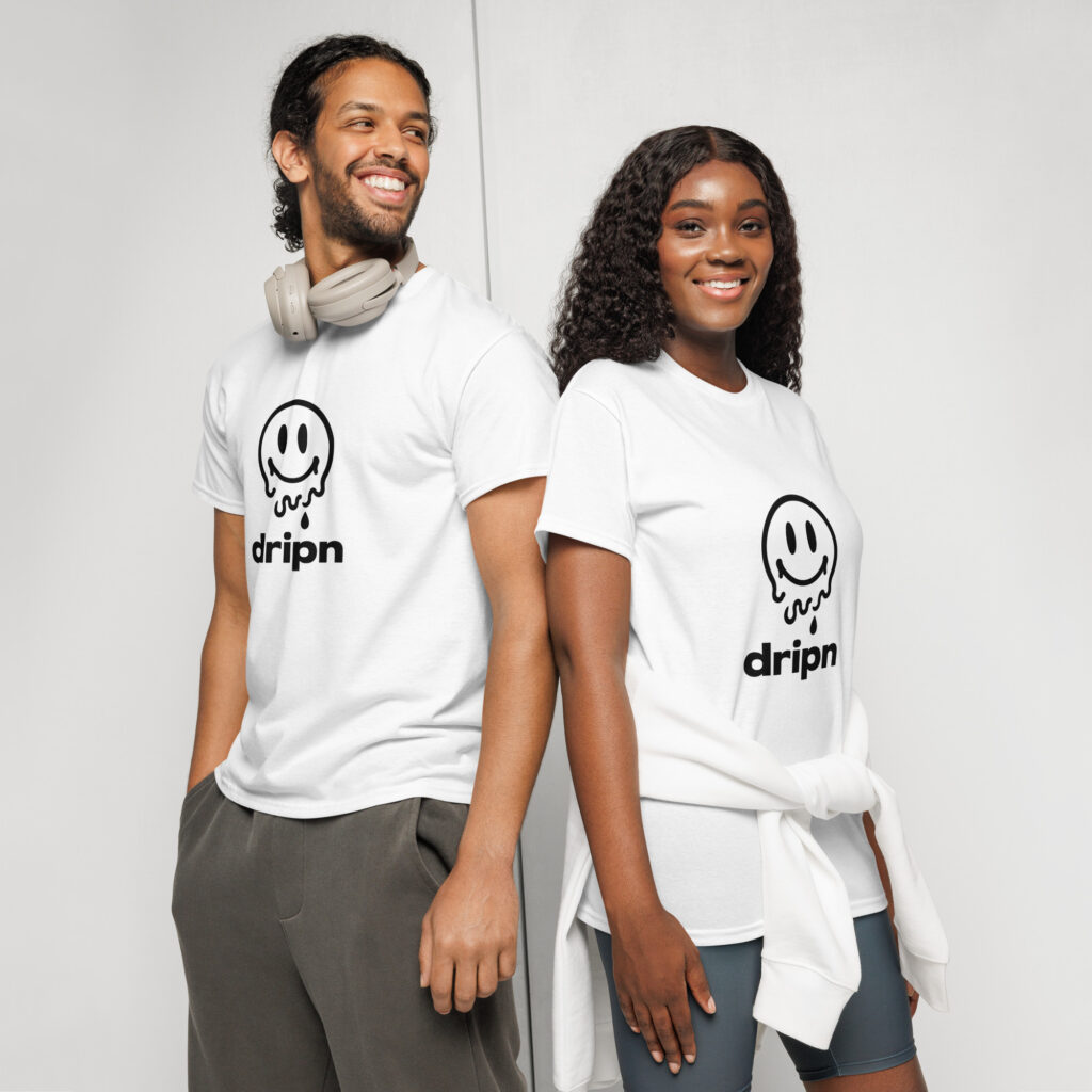 Two smiling people stand back to back in white shirts with a ghost logo, one wearing beige headphones.