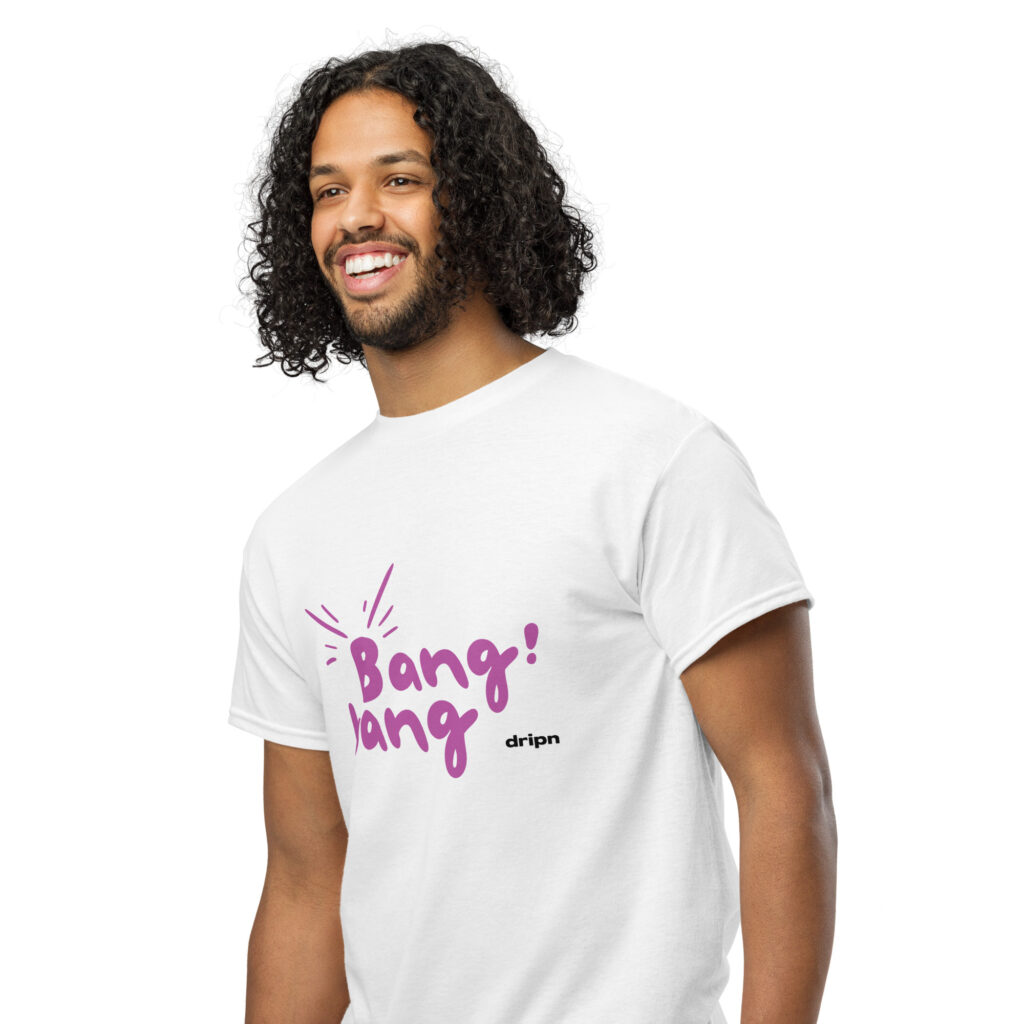 Smiling man with long, curly hair wearing a white T-shirt with a purple graphic text on the front.
